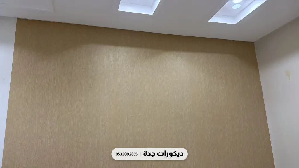 جدار مكتب مغطى بورق بيج بملمس ناعم تحت إضاءة السقف