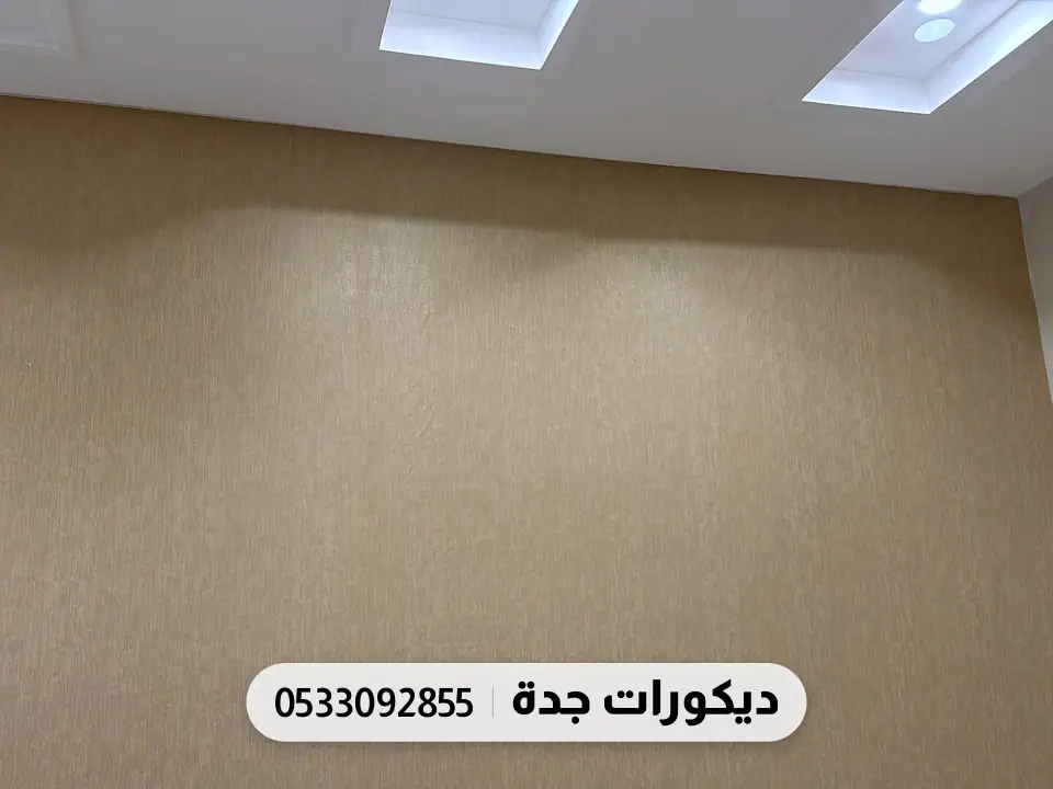 جدار مكتب مغطى بورق بيج بملمس ناعم تحت إضاءة السقف