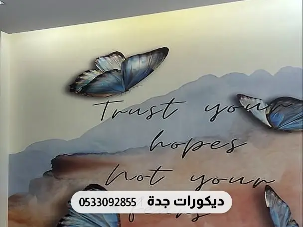 جدارية فراشات زرقاء وعبارة إنجليزية مكتوبة بخط اليد على خلفية فاتحة