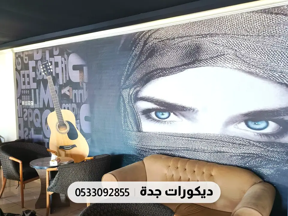 جدارية فنية كبيرة لوجه بعينين زرقاوين خلف جلسات كافيه