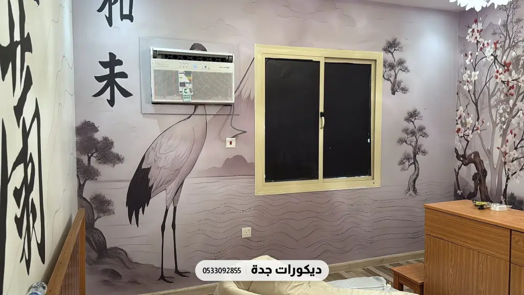 جدارية بطائر كركي وأغصان وحروف يابانية كبيرة على جدار فاتح حول النافذة