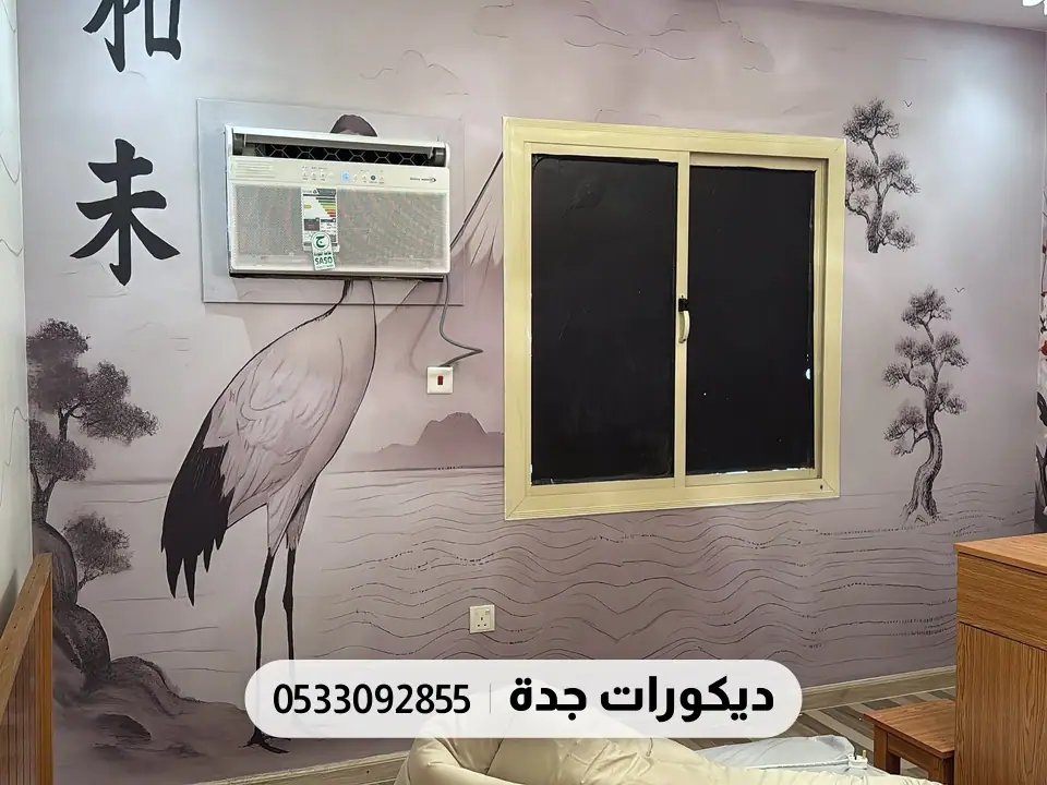 جدارية بطائر كركي وأغصان وحروف يابانية كبيرة على جدار فاتح حول النافذة