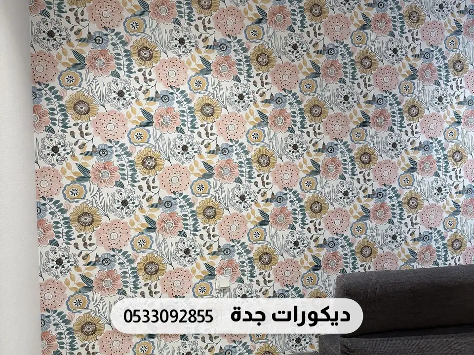 جدار بورق زهور ملوّنة كثيفة بجانب كنبة رمادية