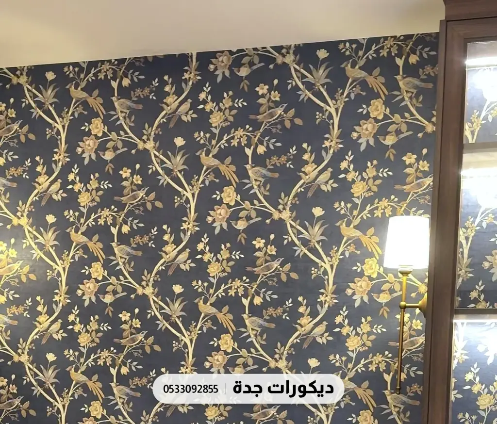 جدار بورق أغصان وأوراق ذهبية على خلفية كحلية بجانب خزانة خشبية