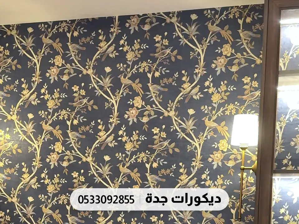جدار بورق أغصان وأوراق ذهبية على خلفية كحلية بجانب خزانة خشبية