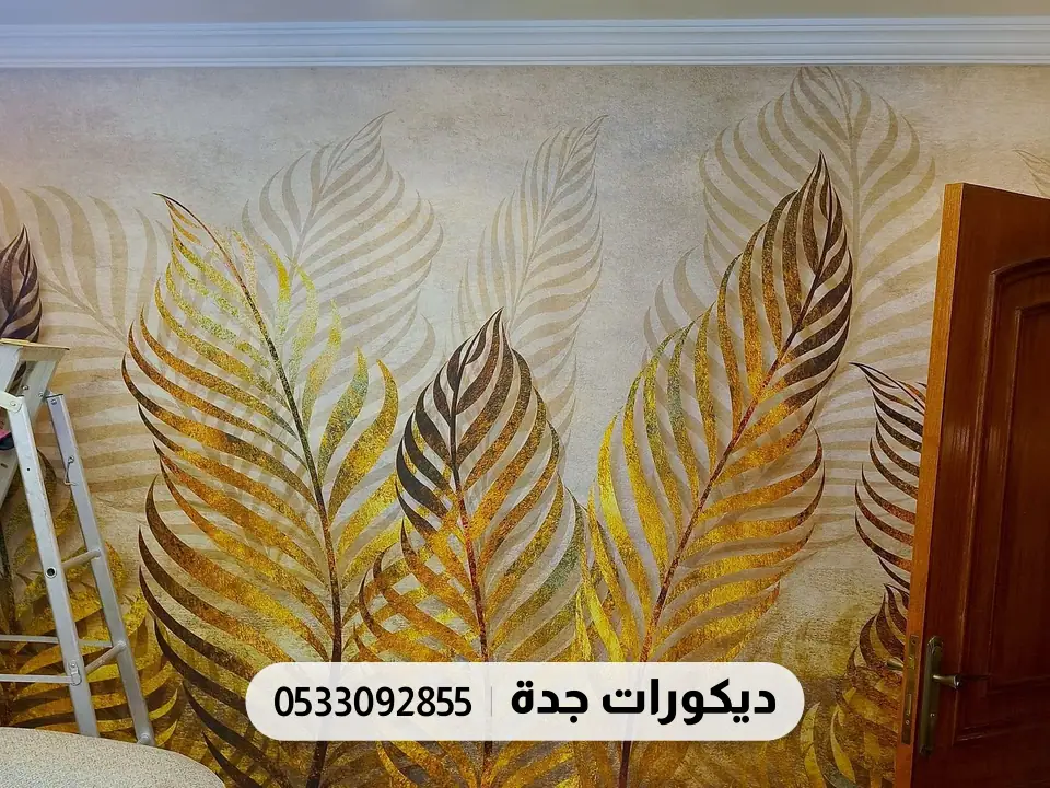 مجلس بجدار مطبوع بأوراق نخيل ذهبية كبيرة خلف كنب بيج