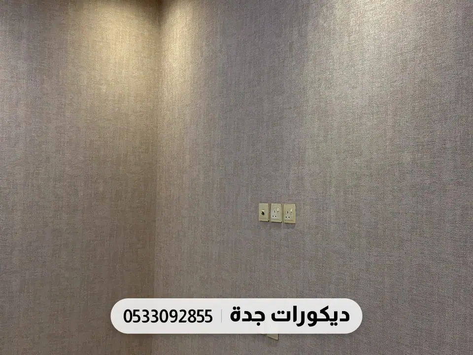 ممر بجدار رمادي بملمس قماشي وإضاءة زرقاء مخفية في السقف