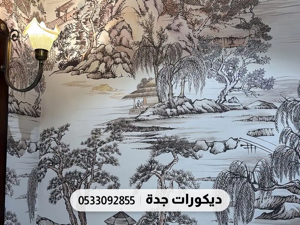 جدارية بأشجار وجبال وجسر بدرجات الرمادي فوق إطارات جبس بيضاء وبجانبها مصباح جداري