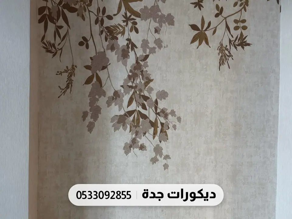 أغصان وأوراق بنية متدلية من أعلى جدار فاتح