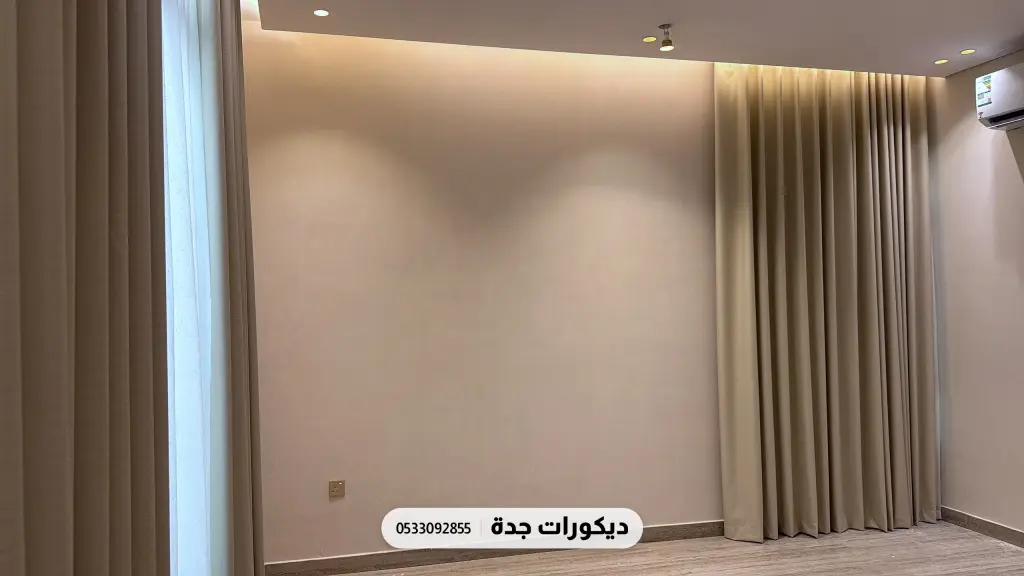 جدار بلون بيج دافئ سادة بإضاءة مخفية بين ستارتين