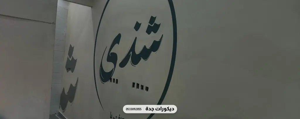 شعار محل شندي مطبوع بالأسود على جدار رمادي داكن