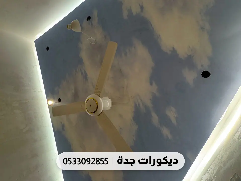 سقف مطبوع بسماء زرقاء وغيوم داخل إطار بإضاءة مخفية
