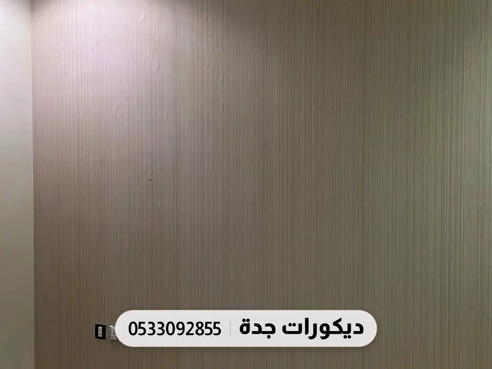 جدار خلف السرير بورق خطوط طولية بلون خشبي دافئ وإضاءة سقف خافتة